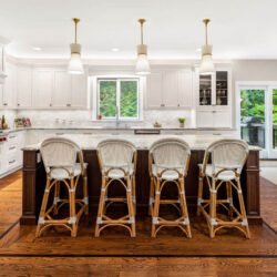 This is a picture of an elegant white kitchen with cherry wood in Henderson NV with custom made cabinetry by Kountry Kraft Cabinetry.