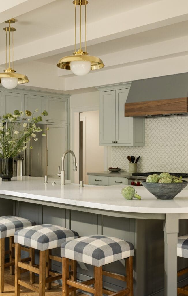 A modern kitchen featuring a central island with bar stools arranged around it for casual dining and socializing.