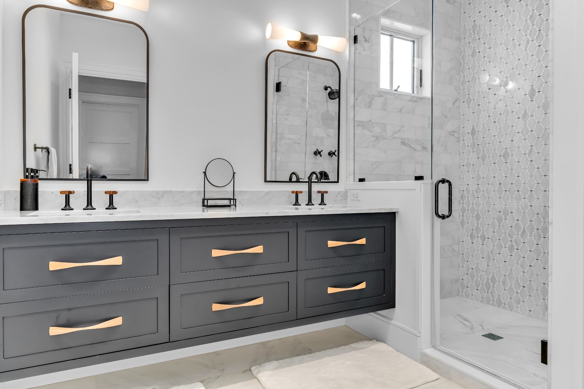 Modern master bathroom with custom bathroom cabinets in Sea Isle City NJ featuring dark painted cabinetry and marble finishes
