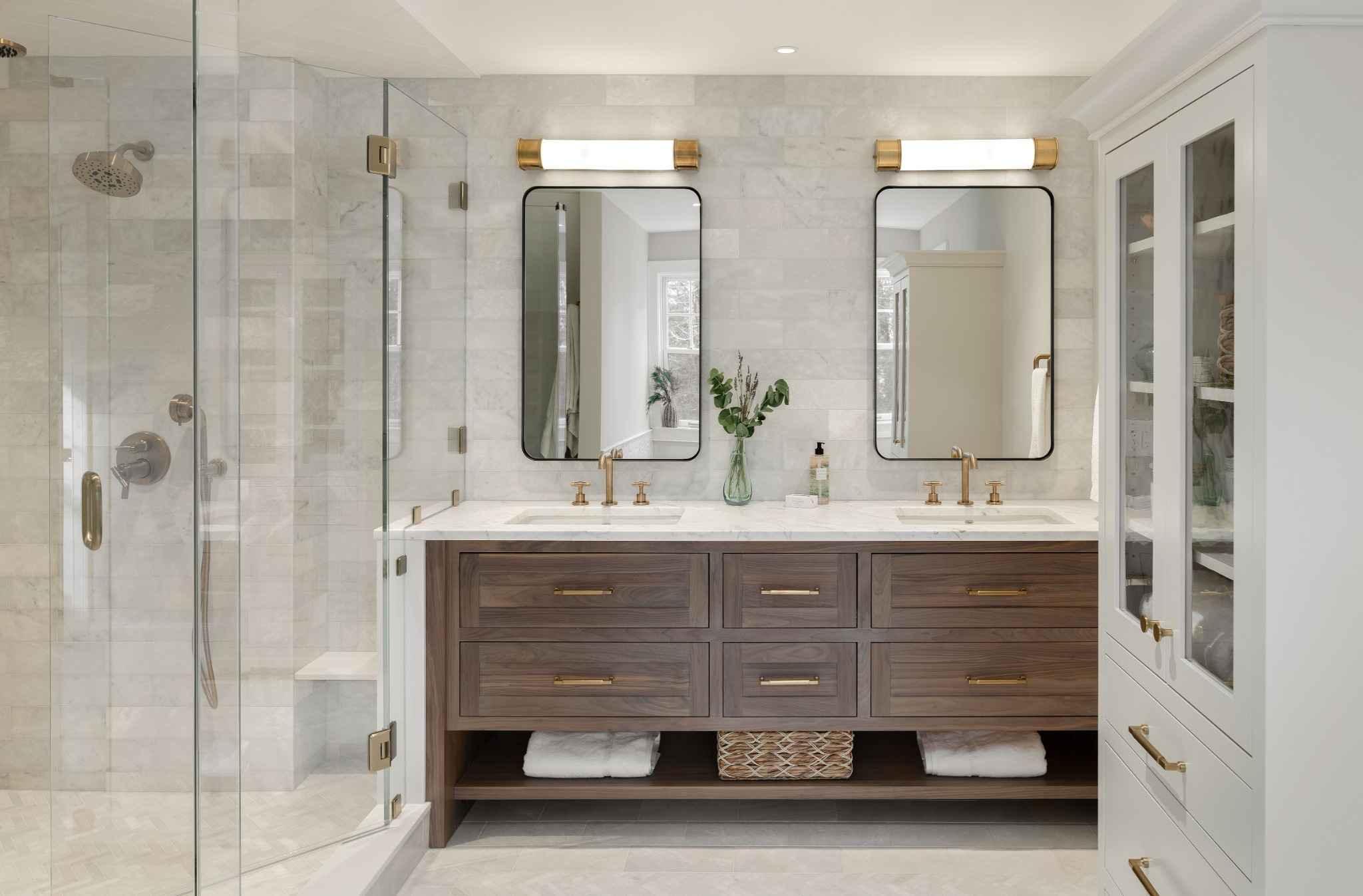 Wide view of an Exeter NH master bath remodel with custom walnut bathroom vanity, tall painted maple cabinet, and glass shower enclosure.