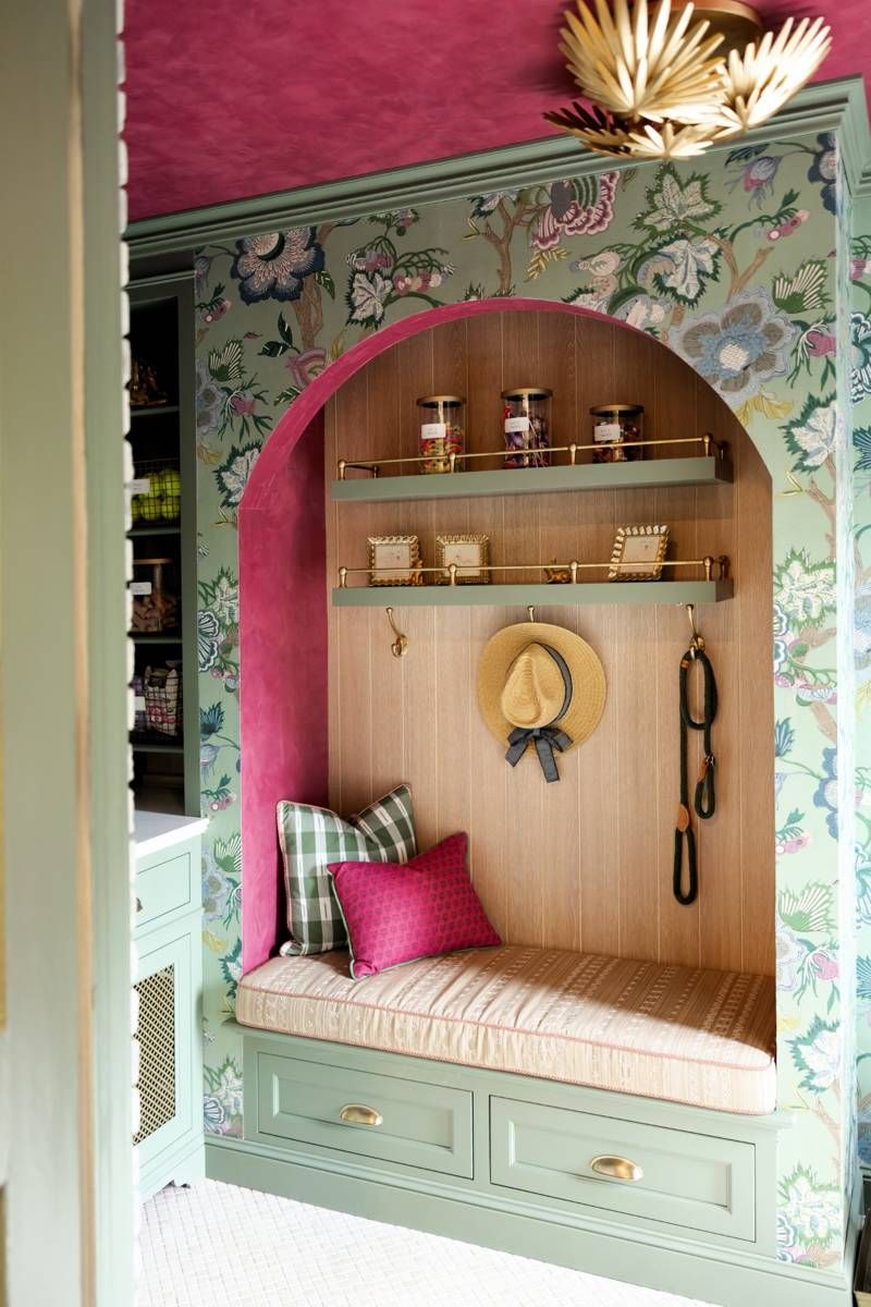 Custom mudroom bench with floral wallpaper, green cabinetry, and pink accent arch, part of the Designer Show House kitchen.