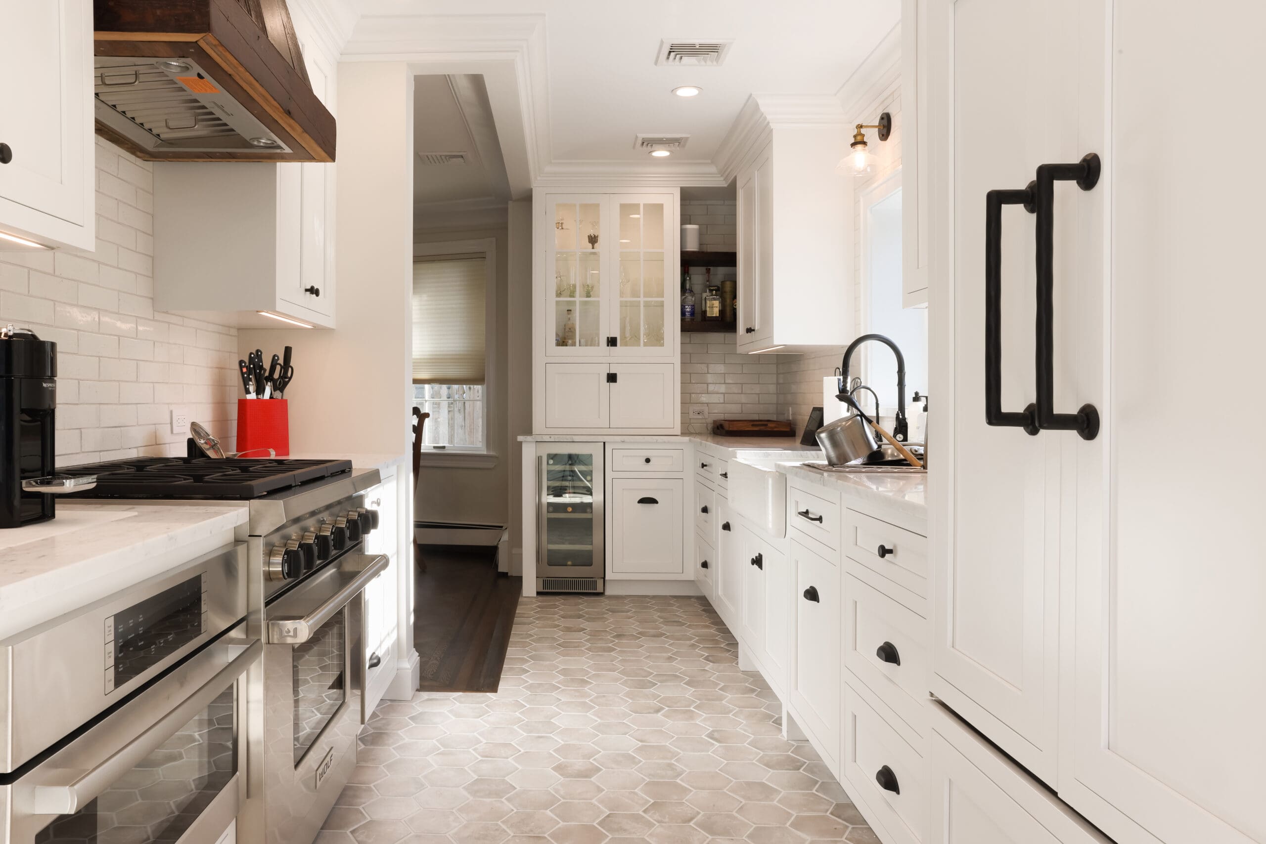Small kitchen cabinetry. Finished in a white paint. Galley style kitchen Stove on the left sink and refrigerator on the right.