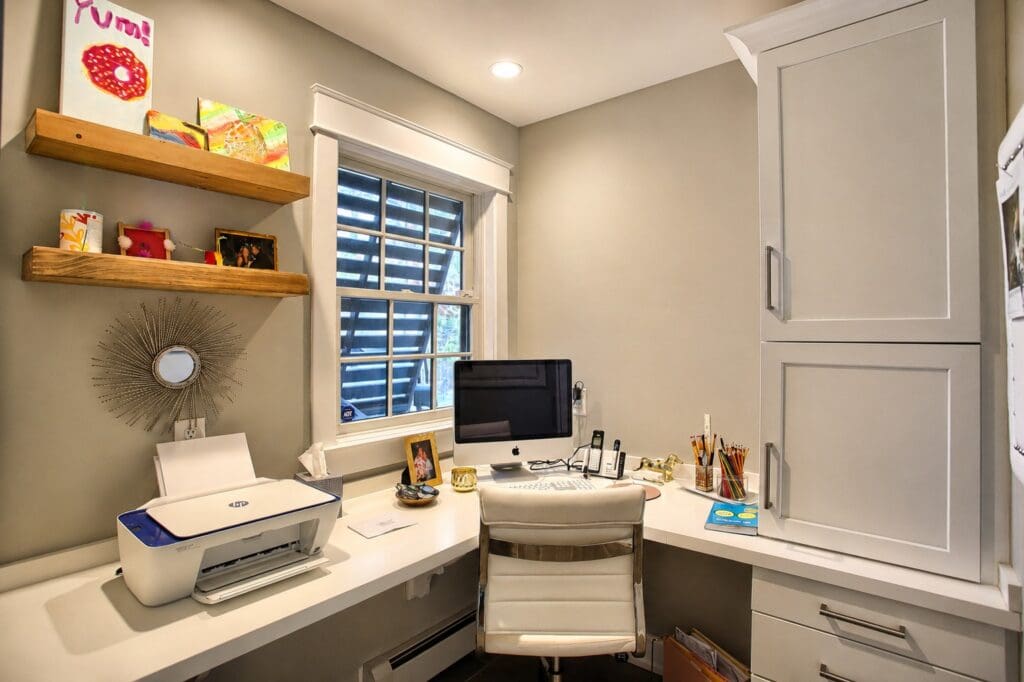 Custom built-in home office cabinetry in the Main Line, PA with an integrated desk, tall storage cabinets, drawers, and open shelving.